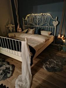 a bedroom with a large bed with a metal headboard at Priča pod kestenom in Palić
