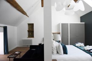 a white bedroom with a bed and a living room at Le Charles V in Meursault