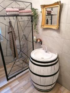 a bathroom with a barrel sink and a mirror at Priča pod kestenom in Palić