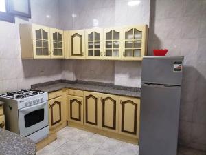 a kitchen with yellow cabinets and a white refrigerator at Mama Africa in Hurghada