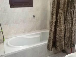 a bathroom with a white tub and a shower curtain at Mama Africa in Hurghada
