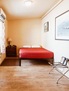 a bedroom with a red bed and a chair at Old Brewery Hostel in Tonopah