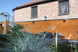 un edificio de ladrillo con una pared de color naranja en Le Fenil Aux Ânes en Walcourt