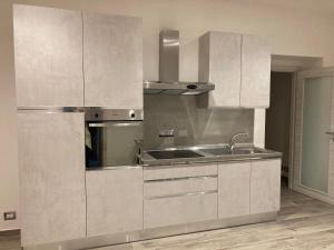 a kitchen with white cabinets and a sink at Manzoni 2 in Turin