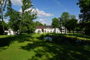 a large white house with trees and a pond at B&O Parkhotel in Bad Aibling