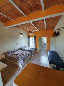 two beds in a room with orange walls at Real del Sol in Rincon de Guayabitos