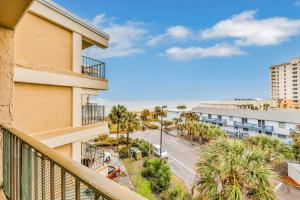 a balcony with a view of a street and palm trees at Jax Beach OceanFront Getaway in Jacksonville Beach