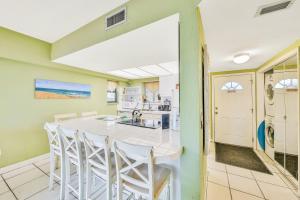 una cocina con una gran mesa blanca y sillas en Jax Beach OceanFront Getaway, en Jacksonville Beach