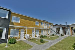 un edificio con sillas blancas en el patio en Kau Si Aike en El Chaltén