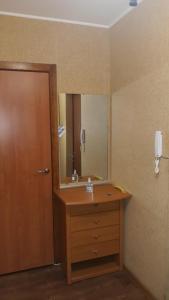 a bathroom with a wooden sink and a mirror at Комфортная 2-комнатная Новопречистенская 1, Три раздельных двуспальных места in Cherkasy