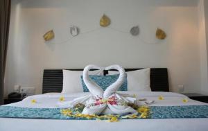 ein Bett mit zwei weißen Schuhen und Blumen drauf in der Unterkunft JK Rooms 147 Lions - Koradi Nagpur in Nagpur