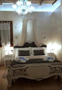 Dormitorio blanco con cama grande y lámpara de araña en Stella del Mar S.Stefano, en Bolonia