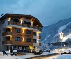 a building with a sign on it in the snow at Apart Platzer in Zell am Ziller