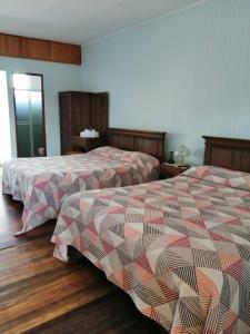 two beds in a hotel room with two beds sidx sidx sidx at Hotel Las Brumas in Cartago