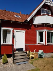 a red house with a white door and a porch at Båstad Stationsterrassen 7 in Båstad