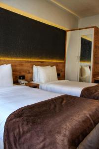 een hotelkamer met 2 bedden en een zwarte muur bij ESKOPPremium OTEL in Bolu