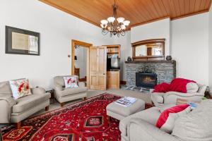a living room with couches and a fireplace at Historic Stonehouse & Alley Cottage - Sleeps 14 with spa pool in Queenstown