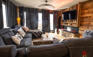sala de estar con sofá grande y chimenea en spot, exceptl 80 m2, centre Alpe d Huez, ski au pied, Ménandière, 8 pers, 3ch, 3sdb en L'Alpe-d'Huez