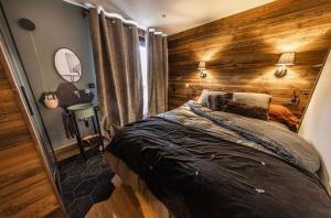 1 dormitorio con una pared de madera y 1 cama en spot, exceptl 80 m2, centre Alpe d Huez, ski au pied, Ménandière, 8 pers, 3ch, 3sdb en L'Alpe-d'Huez