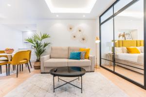 a living room with a couch and a bed at Debambú Suites in Málaga