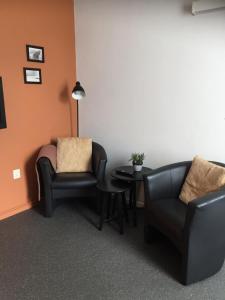 a living room with two chairs and a table at Studio met woonslaapkamer,keuken en badkamer Dreefje 5 in Westkapelle