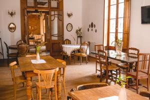 a dining room with tables and chairs and windows at Posada Los Angelos in Ramallo
