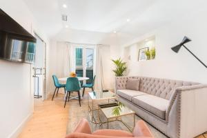 a living room with a couch and a table at Debambú Suites in Málaga