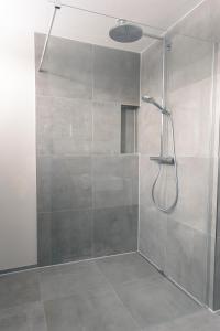 La salle de bains est pourvue d'une douche avec une porte en verre. dans l'établissement SeeZeichen-Apartment No 26, à Bodman-Ludwigshafen
