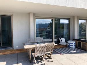 a patio with a table and chairs and windows at SeeZeichen-Apartment No 26 in Bodman-Ludwigshafen