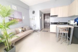 a living room and kitchen with a couch and a table at Cebu City Apartment - Mabolo Gardens in Cebu City