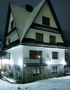 扎科帕內的住宿－Pokoje u Agi，一座白色的大建筑,在雪中设有阳台