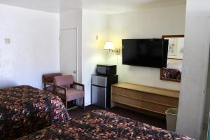 Habitación de hotel con 2 camas y TV de pantalla plana. en Economy Inn en Tucson