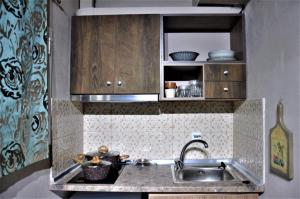 una cocina con fregadero y armarios de madera en Grecian Sea en Limenaria