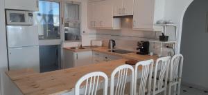 ミハス・コスタにあるApartment Riviera del Sol - Seaviewのキッチン(木製テーブル、白いキャビネット付)