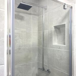 a bathroom with a shower with a glass door at Part St Apartments in Southport