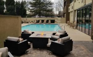 a swimming pool with chairs and a table and a table and a tablektop at Holiday Inn Denver Lakewood by IHG in Lakewood