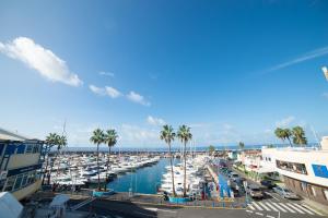 Un puerto deportivo con barcos en el agua y palmeras. en Bungalow Club Atlantis, en Adeje