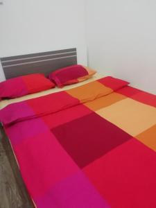 een bed met een kleurrijk dekbed en kussens erop bij 1 ком квартира с газом вблизи ЖД вокзала in Odessa