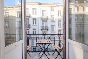 a balcony with a table and chairs and a view of a city at The Good House in Brussels