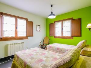 Dormitorio verde con 2 camas y ventanas en Belvilla by OYO Casa de campo Villanueva de Oscos en Villanueva de Oscos