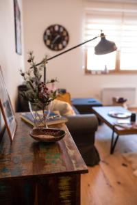 ein Wohnzimmer mit einem Tisch und einer Vase darauf in der Unterkunft Amber Gold Apartment in Zlatibor