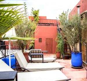een patio met stoelen en bomen en een gebouw bij Riad Bobby Marrakech in Marrakesh