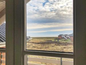 una ventana con vistas al campo y a las casas en 4 person holiday home in R m en Rømø Kirkeby