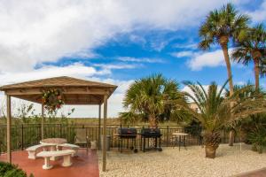 a patio with a gazebo and palm trees at #102 Madeira Norte Condo in St. Pete Beach