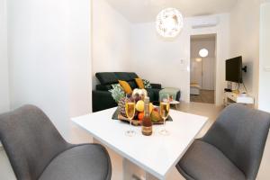 ein Wohnzimmer mit einem weißen Tisch und 2 Stühlen in der Unterkunft Four modern apartment's at antique Villa, Castropola 8, Pula, City Center in Pula