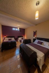 una habitación de hotel con 2 camas y equipaje en 7 orejas, en Quetzaltenango