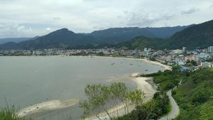 una vista di una spiaggia con una città sullo sfondo di Cantinho da paz 01 a Caraguatatuba