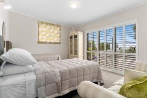 Un pat sau paturi într-o cameră la The Cottage - Te Puke Holiday Home