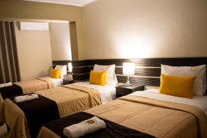 a hotel room with two beds with yellow pillows at Hotel San Martin in Tarapoto