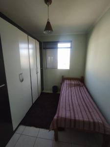 a room with a bed in a room with a window at Apto 2 quartos, cond fechado, com vaga, quarto andar in Pelotas